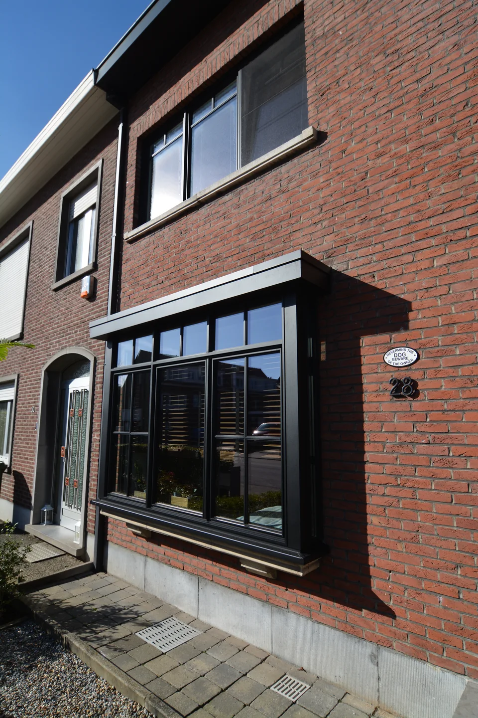 Bakstenen woninggevel met donkere raamprofielen