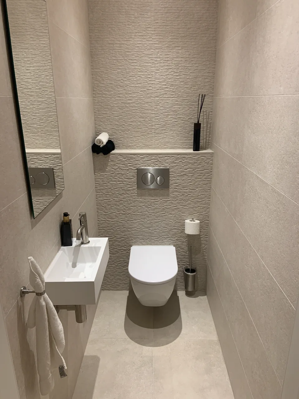 Afgewerkte toiletruimte met hangtoilet en wastafel