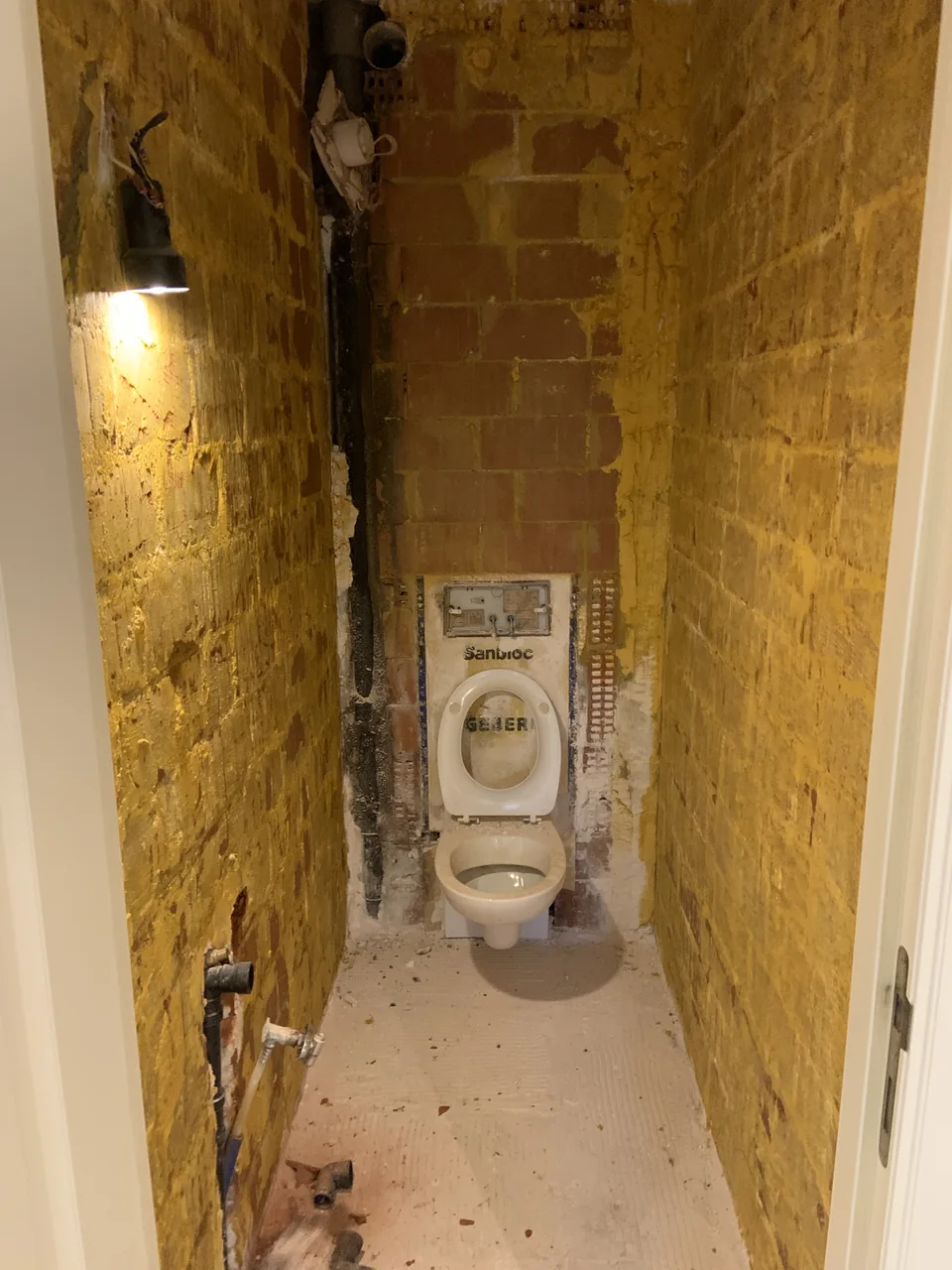 Toiletruimte met open muren tijdens de werken